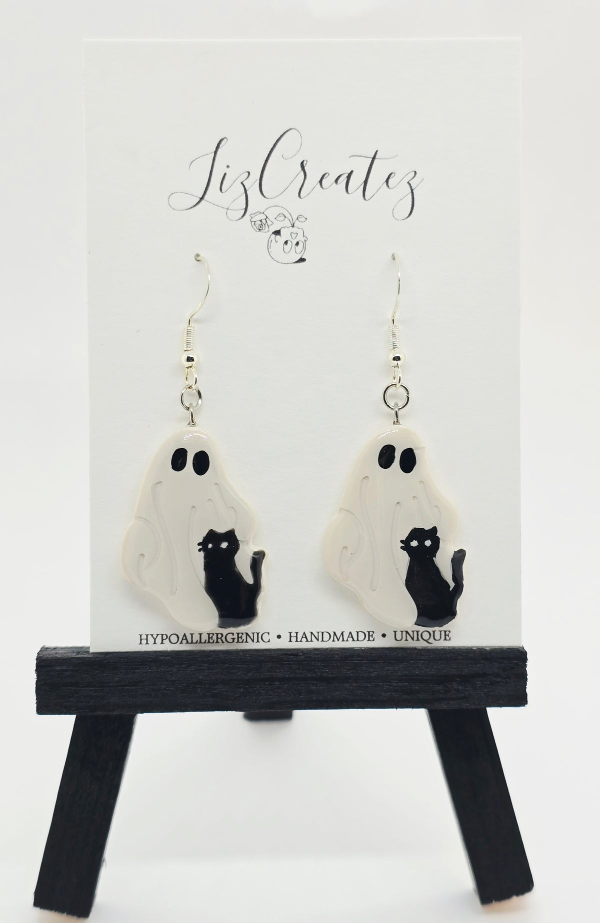 Hand-sculpted polymer clay earrings of a ghost petting a black cat, coated in glossy resin