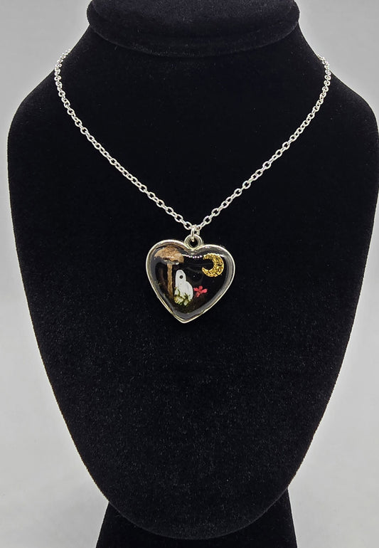 Silver heart pendant necklace with a hand-painted ghost under a real mushroom and gold moon, on an 18-inch silver chain